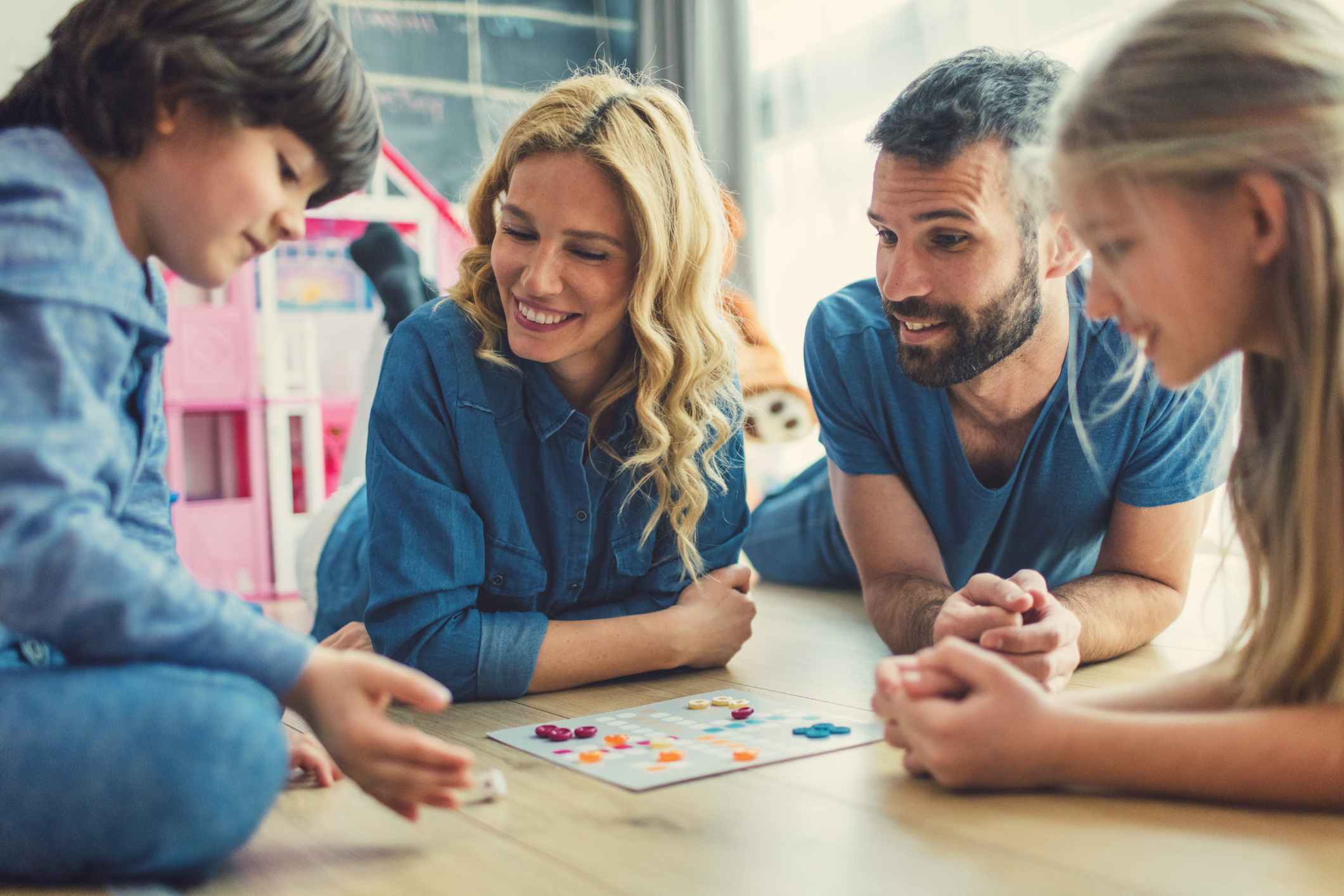 Family playing educational board game together building math confidence